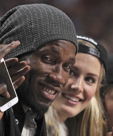 Montreal Impact soccer player Didier Drogba sits next to tennis star Eugenie Bouchard at the Toronto Raptors/ Washington Wizards National Basketball League pre-season game in Montreal Friday October 23, 2015.