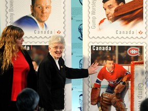 Doreen  Worsley, widow of late NHL goaltending legend Lorne (Gump) Worsley, unveils a new Canada Post stamp featuriing her late husband at a Hockey Hall of Fame ceremony in Toronto on Oct. 1, 2015. With her is her daughter, Lianne.