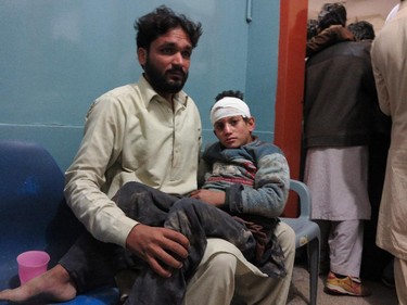A Pakistani man holding his son waits for medical help at a local hospital in Mingora, Pakistan, Oct. 26, 2015. A powerful 7.7-magnitude earthquake in northern Afghanistan rocked cities across South Asia.