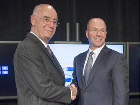 Alain Bellemare, president and Chief Executive Officer Bombardier Inc., right, and Quebec Economy Minister Jacques Daoust shake hands after a news conference Thursday, October 29, 2015 in Montreal. The Quebec government is investing $1 billion in Bombardier's CSeries aircraft program.