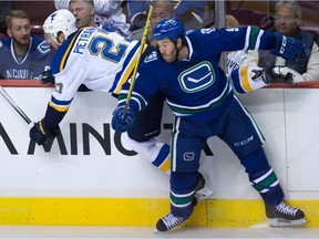 St. Louis Blues' Alex Pietrangelo, left, and Vancouver Canucks' Brandon Prust collide during the second period of an NHL hockey game in Vancouver, B.C., on Friday, Oct. 16, 2015.