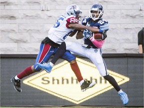 Montreal Alouettes' B.J. Cunningham, left, challenges Toronto Argonauts' A.J. Jefferson during second half CFL football action in Montreal, Monday, October 12, 2015.