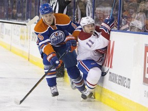 Montreal Canadiens' Brendan Gallagher (11) is checked by Edmonton Oilers' Mark Fayne (5) during first period NHL action in Edmonton Oct. 29, 2015.