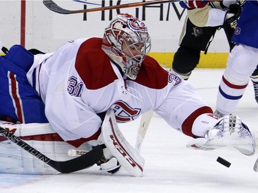 Montreal Canadiens goalie Carey Price (31) covers a loose puck with this glove during the second period of an NHL hockey game against the Pittsburgh Penguins in Pittsburgh Tuesday, Oct. 13, 2015.