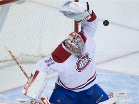 The puck deflects off the glove of Canadiens goalie Carey Price and drops behind him before being put in the net for a goal by the Canucks' Jared McCann during game in Vancouver on Oct. 27, 2015. The Canucks won 5-1.