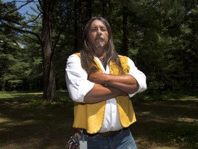 Kanesatake Grand Chief Serge Simon stands in the Pines Thursday, June 18, 2015 in Kanesatake, Que., near the scene of the police raid 25 years ago that started the Oka Crisis. July 11, 2015 will mark the 25th anniversary of the start of the Oka Crisis. THE CANADIAN PRESS/Ryan Remiorz