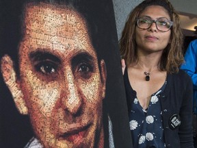 Ensaf Haidar, wife of Raif Badawi, stands next to a poster of a book of articles written by the imprisoned Saudi blogger, Tuesday, June 16, 2015 in Montreal. Badawi, who isimprisoned for criticizing Islam on his blog, is currently serving a 10-year prison sentence and is also supposed to receive 1,000 lashes delivered in batches of 50 over 20 weeks.