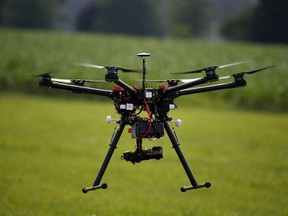 FILE - In this June 11, 2015 file photo, a hexacopter drone is flown during a drone demonstration at a farm in Cordova, Md. Concerned about rising reports of close calls and safety risks involving drones, the government announced Monday it will require many of the increasingly popular unmanned aircraft to be registered.