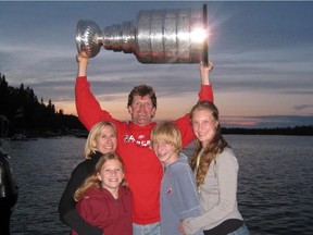 Mike Babcock hoists the Stanley Cup at the family cottage on Emma Lake, Sask., in the summer of 2008. He's joined by his wife Maureen, and (from left) their children Taylor, Michael and Allie.
