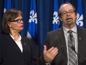 Quebec Native Affairs Minister Geoffrey Kelley responds to questions over the Val-D'Or natives accusations on police officers, Tuesday, October 27, 2015 in Quebec City. Quebec Minister for Rehabilitation, Youth Protection and Public Health Lucie Charlebois, left, looks on.