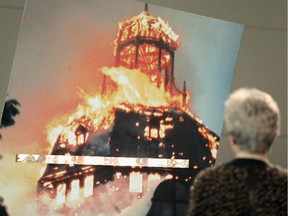 A visitor to a 2013 Berlin museum exhibit observes a photograph of a synagogue burning during Kristallnacht. The Sacred Echoes commemoration at Congregation Shaar Hashomayim will feature virtual reconstructions of Germany's synagogues.
