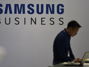 A man works on a laptop at the Samsung booth at a technology fair.