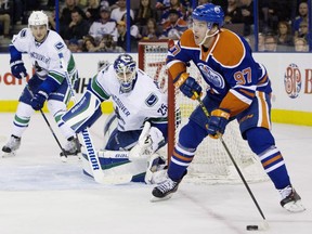 Vancouver Canucks goalie Jacob Markstrom (25) and Dan Hamhuis (2) keep an eye on Edmonton Oilers' Connor McDavid (97) during second period NHL pre-season action in Edmonton, Alta., on Thursday October 1, 2015.