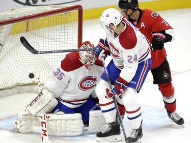 The puck enters the net behind Montreal Canadiens goaltender Dustin Tokarski (35) off a shot by Ottawa Senators' Cody Ceci (5, not shown) as Canadiens' Jarred Tinordi (24) and Senators' Kyle Turris (7) look on during the third period of a pre-season NHL hockey game, Saturday, October 3, 2015, in Ottawa.