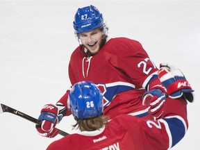 Montreal Canadiens' Jeff Petry (26), bottom, celebrates with teammate Alex Galchenyuk (27) after scoring against the Detroit Red Wings during third period NHL hockey action in Montreal, Saturday, Oct. 17, 2015.