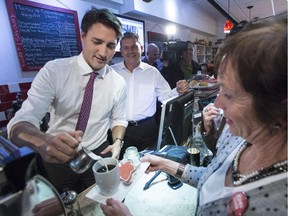 Liberal leader Justin Trudeau serves coffee to customers at a coffee shop, Monday, October 5, 2015 in Oakville, Ont., during a campaign stop.