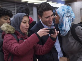 A woman kisses prime minister-designate Justin Trudeau as he greets constituents at a subway station in his riding Tuesday, October 20, 2015 in Montreal, the morning after winning a majority government in the federal election.
