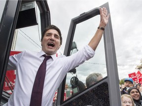 Liberal Leader Justin Trudeau waves from his bus as he arrives for a campaign event Wednesday, October 14, 2015 in St. Catharines, Ont.