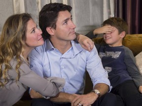 Xavier Trudeau covers his eyes as Liberal leader Justin Trudeau watches the results with his wife Sophie Gregoire at a hotel in downtown Montreal on Monday, Oct. 19, 2015. THE CANADIAN PRESS/Paul Chiasson