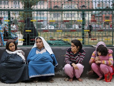 Kashmiri women sit on a footpath after they rushed out of buildings following tremors in Srinagar, Indian controlled Kashmir, Oct. 26, 2015.