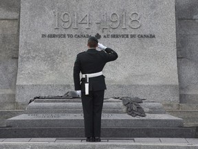 Sgt. Kyle Button salutes as he stands infant of the Tomb of the Unknown Soldier at the National War Memorial in Ottawa, Wednesday Oct. 21, 2015.