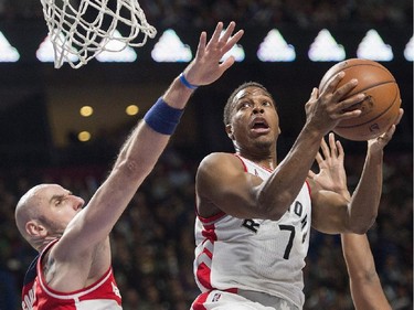 Toronto Raptors' Kyle Lowry, right, drives to the basket as Washington Wizards' Marcin Gortat defends during first quarter NBA pre-season basketball action in Montreal, Friday, October 23, 2015.