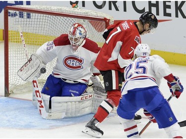 Montreal Canadiens goaltender Dustin Tokarski (35) keeps his eye on the puck as Jacob De La Rose (25) and Ottawa Senators' Kyle Turris (7) battle during the second period of a pre-season NHL hockey game, Saturday, October 3, 2015, in Ottawa.