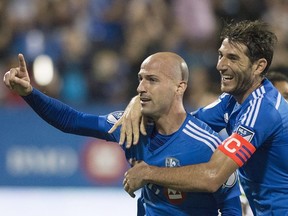 Montreal Impact's Laurent Ciman, left, celebrates with teammate Ignacio Piatti after scoring against the Seattle Sounders during second half MLS soccer action in Montreal, Saturday, July 25, 2015.