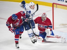 Toronto Maple Leafs' Leo Komarov, centre, moves in on Montreal Canadiens goaltender Carey Price as Canadiens' Andrei Markov (79) defends during third period NHL hockey action in Montreal, Saturday, October 24, 2015.