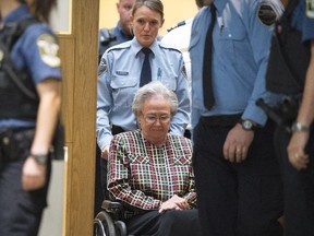 Former Quebec lieutenant governor Lise Thibault is escorted by agents, leaving the courtroom after receiving an 18-month prison sentence, Wednesday, September 30, 2015 at the courthouse in Quebec City.