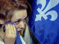 Twenty years ago, on Oct. 30, 1995, a heartbroken Oui supporter wipes her tears with the Quebec flag.