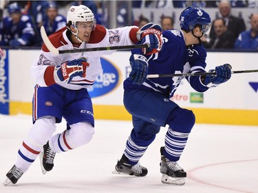 Montreal Canadiens' Brian Flynn (32) and Toronto Maple Leafs' Scott Harrington (36) race towards the puck during first period NHL action in Toronto on Wednesday, Oct. 7, 2015.