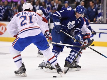 Montreal Canadiens' Devante Smith-Pelly (21) and Toronto Maple Leafs' Dion Phaneuf (3) battle for control of the puck during second period NHL action in Toronto on Wednesday, Oct. 7, 2015.
