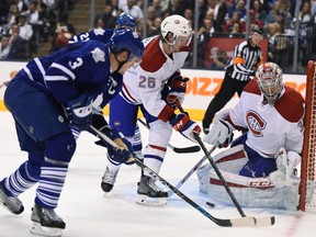 Montreal Canadiens goalie Carey Price makes a save as Toronto Maple Leafs' Dion Phaneuf (3) and Canadiens' Jeff Petry (26) look for a rebound during second period NHL action in Toronto on Wednesday, Oct. 7, 2015.