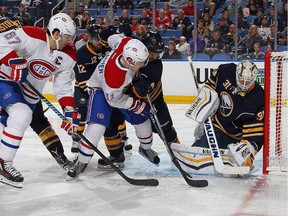Canadiens' Brendan Gallagher, #11, scores a second period goal, slipping it past Sabres' Chad Johnson as Habs captain Max Pacioretty watches Friday night in Buffalo.