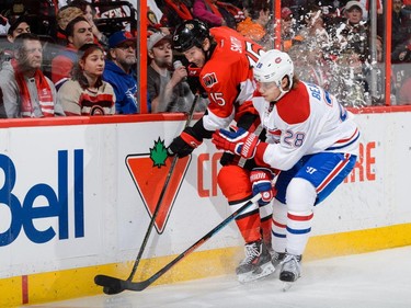 Nathan Beaulieu #28 of the Montreal Canadiens checks Zack Smith #15 of the Ottawa Senators near the boards during the NHL game at Canadian Tire Centre on October 11, 2015 in Ottawa.