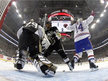 Tomas Plekanec (#14) of the Montreal Canadiens celebrates a goal by Max Pacioretty (#67) (not pictured) in the first period as Marc-André Fleury (#29) and Kris Letang (#58) of the Pittsburgh Penguins react during the game at Consol Energy Center on October 13, 2015 in Pittsburgh, Pennsylvania.