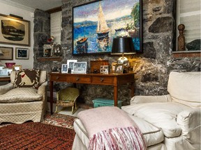 Sharyn Scott lives in what would be called a 'mews flat' in London, down a laneway in what used to be the apartment building garage. The open design of the 1,150-square-foot apartment in Westmount, on has stone walls where every inch is hung with original artwork. (Dave Sidaway / MONTREAL GAZETTE)