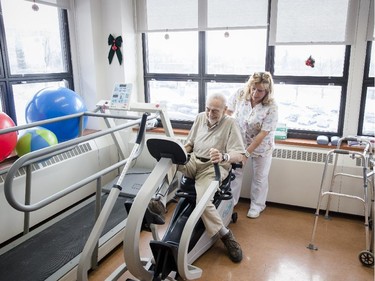 MONTREAL, QUE.: DECEMBER 18, 2013 -- Eighty-six year-old Albert Spiegel is assisted by Physical and occupational therapy attendant Celine Hebert as he demonstrates one of his therapy machines at the Institut de réadaptation Gingras-Lindsay-de-Montréal in Montreal on Wednesday, December 18, 2013. Spiegel suffered a heart attack while taking his dog to be put down and was given an emergency dose of medication which left his left leg paralyzed. (Dario Ayala / THE GAZETTE) ORG XMIT: 48815