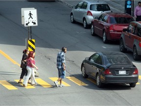 A car drives through a crosswalk on Peel St. near the intersection at Cypress St. in Montreal.