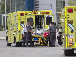 Ambulance and medical staff wheel an incubator from an ambulance at the MUHC Glen Campus in May.