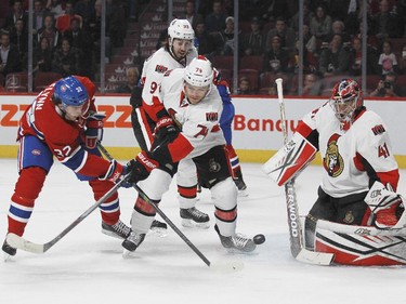 Montreal Canadiens Brian Flynn takes a shot on Ottawa Senators goalie Craig Anderson while being checked by Mark Borowieki, (#74) and Mika Zibanejad during a National Hockey League pre-season game in Montreal Thursday October 1, 2015.