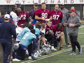 Alouettes head coach Jim Popp, right, speaks to his players following practice on Monday Oct. 5, 2015.