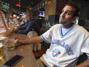 Toronto Blue Jays fan and Toronto native Sam Bhachech watches the Jays American League playoff game on the one television out of six near the bar at Sports Station bar in Montreal Thursday Oct. 8, 2015.  Bhachech is wearing a Joe Carter Blue Jays jersey. Carter was the hero of the Jays 1993 World Series-winning team.