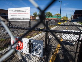A sign protesting a fence blocking a sidewalk and bicycle path at the AMT Parc station in the neighbourhood of Parc-Extension in Montreal on Saturday, October 10, 2015. The sign, which reads, "You are a few steps away from crossing, a fence is stopping you," is asking for citizens to complain to the AMT and the Canadian Pacific Railway company in order to remove the fence that blocks a bicycle path and sidewalk.
