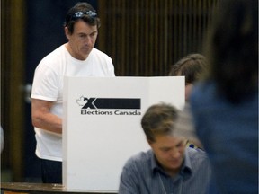 Parti Québécois Leader Pierre Karl Péladeau, centre, votes in Outremont on Monday October 12, 2015, during the last day of advance polling for the October 19 federal elections.