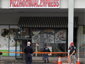 Police at Pizza Dorval Express in Dorval, west of Montreal Oct. 13, 2015.  The pizzeria was hit with a molotov cocktail earlier in the morning.