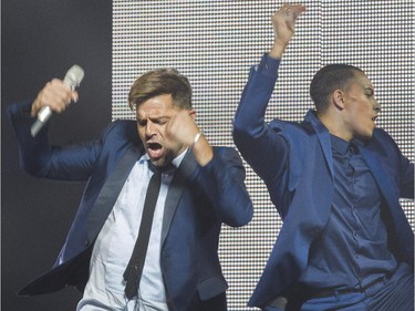 Latin pop singer Ricky Martin (left) performs beside one of his dancers at the Bell Centre Wednesday, October 14, 2015 in Montreal.