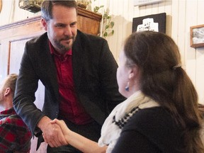 Alexandre Boulerice, left, NDP candidate and incumbent in Rosemont--La-Petite-Patrie, in his riding on Thursday, October 15, 2015, shakes  hands with a potential voter in a local bar.