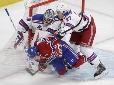 Brendan Gallagher of the Montreal Canadiens is checked by Ryan McDonagh of the New York Rangers in front of goalie Henrik Lundqvist in the first period in NHL action at the Canadiens' home opener at the Bell Centre Thursday, October 15, 2015 in Montreal.